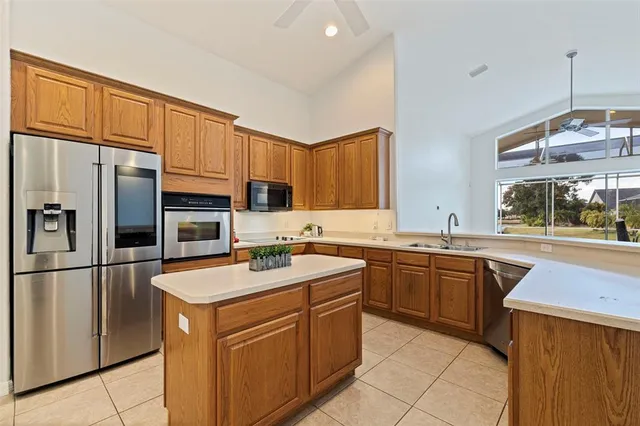 a kitchen with stainless steel appliances granite countertop a sink stove refrigerator and cabinets