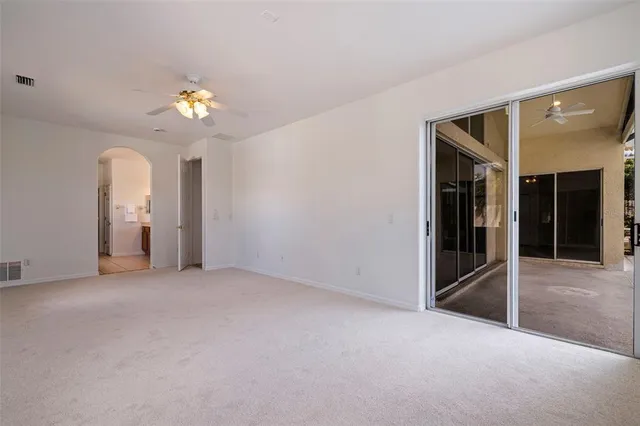 an empty room with a furniture cabinet ceiling fan and window