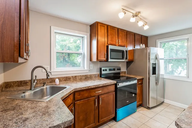 a kitchen with granite countertop a stove sink and refrigerator