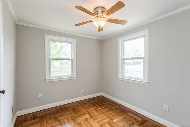 an empty room with windows and fan