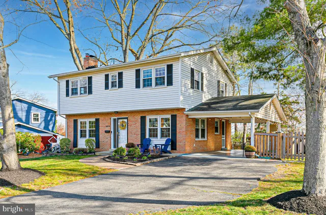 a view of a dining room and livingroom with furniture wooden floor a rug a chandelier