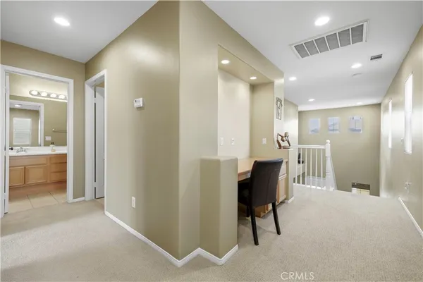 a view of a hallway with bathroom and a bathroom