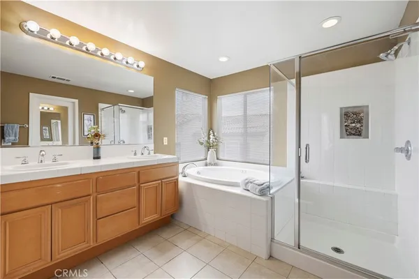 a spacious bathroom with a shower a sink and mirror with bathtub