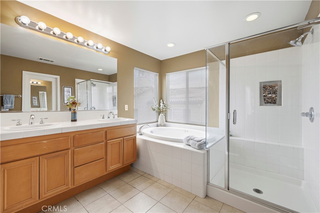 28940 Mirada Circulo Valencia, CA 91354 - Photo 16 of 25 a spacious bathroom with a shower a sink and mirror with bathtub