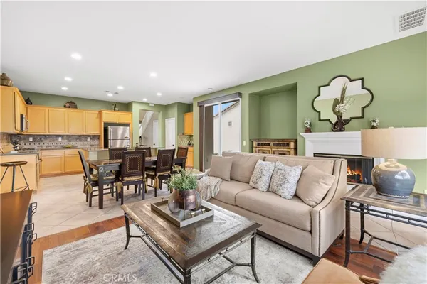 a living room with furniture kitchen view and a large window