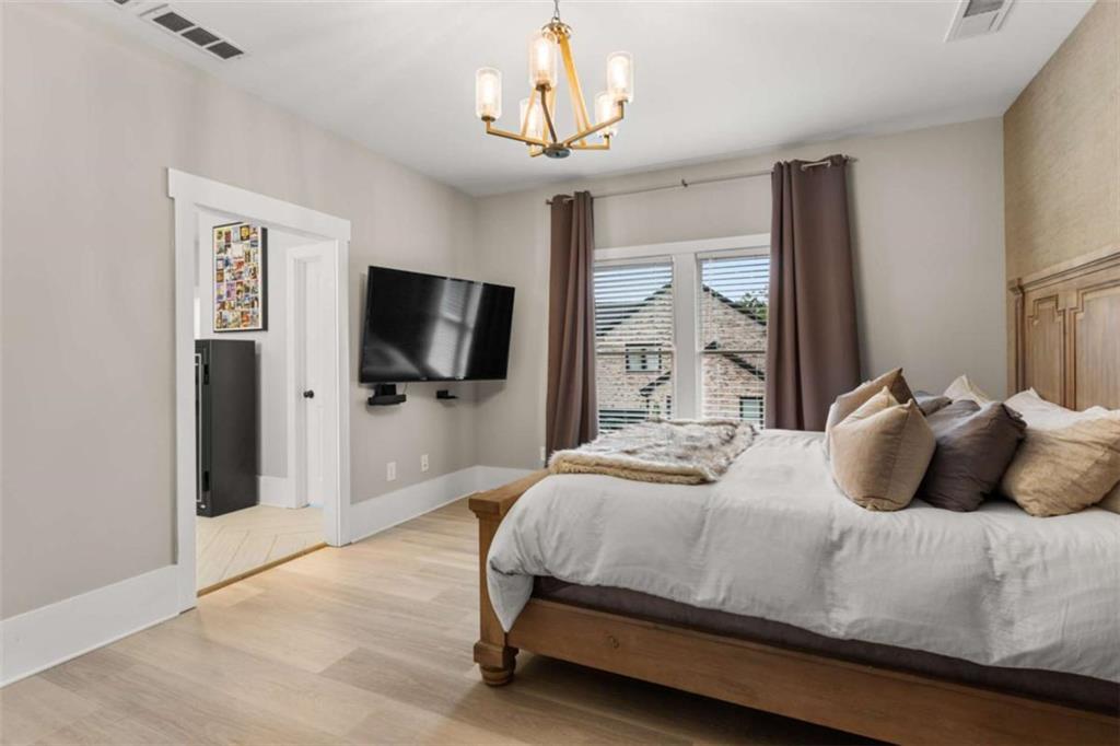 1585 Dabbs Bridge Road Dallas, GA 30132 - Photo 16 of 32 a bedroom with a bed flat screen tv and a chandelier