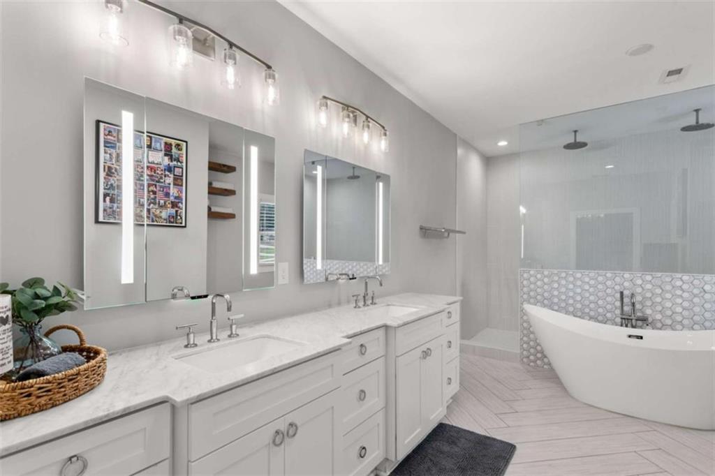 1585 Dabbs Bridge Road Dallas, GA 30132 - Photo 19 of 32 a spacious bathroom with a double vanity sink a large mirror and a bathtub