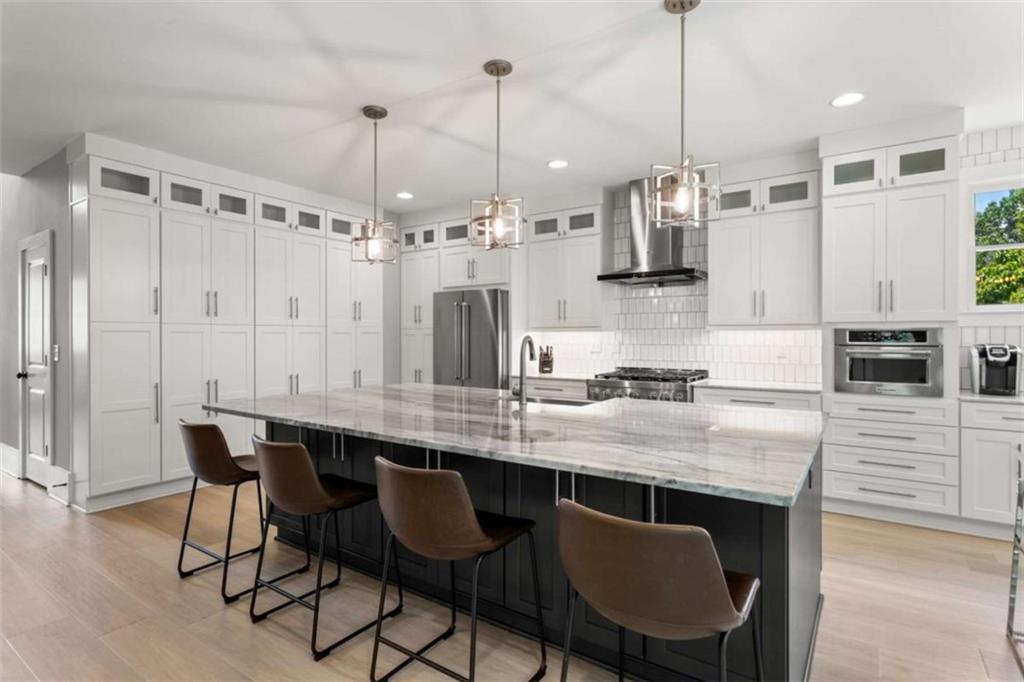 1585 Dabbs Bridge Road Dallas, GA 30132 - Photo 6 of 32 a kitchen with stainless steel appliances granite countertop a sink a stove a refrigerator and a wooden floor