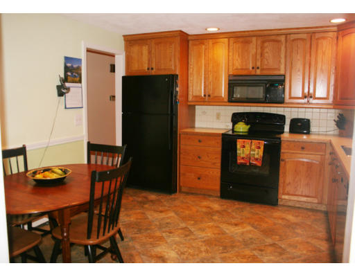 36 Hemlock Road Reading, MA 01867 - Photo 4 of 14 a kitchen with stainless steel appliances kitchen island granite countertop a refrigerator a stove a sink dishwasher with a dining table and chairs