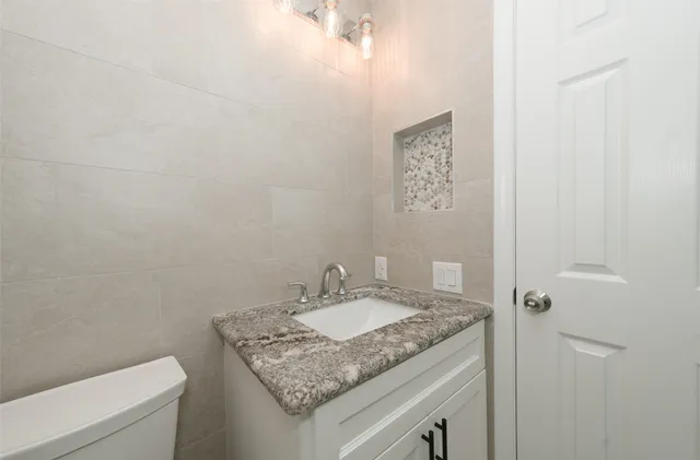 a bathroom with a granite countertop sink and a mirror