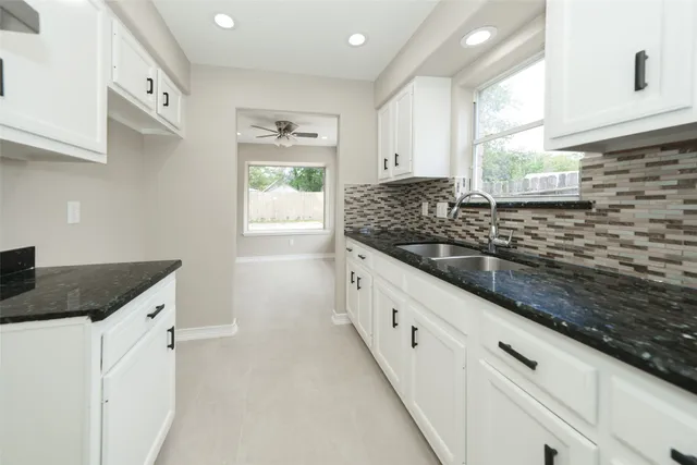 a kitchen with granite countertop a sink and a stove