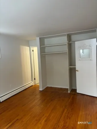 an empty room with wooden floor and closet