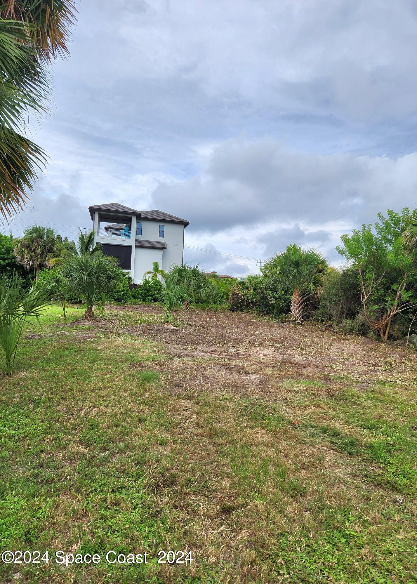 7308 Stuart Avenue Melbourne Beach, FL 32951 - Photo 11 of 16 a view of a big yard with a house in the background