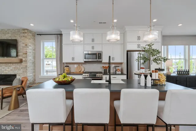 a kitchen with a dining table chairs and kitchen view
