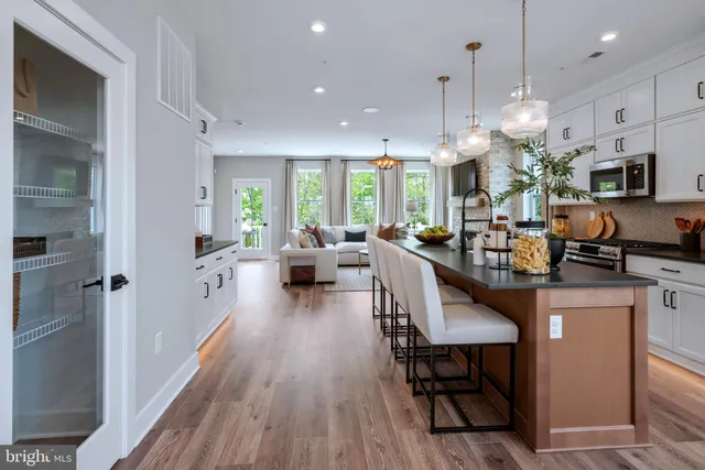 a view of a dining room and livingroom with furniture wooden floor a chandelier