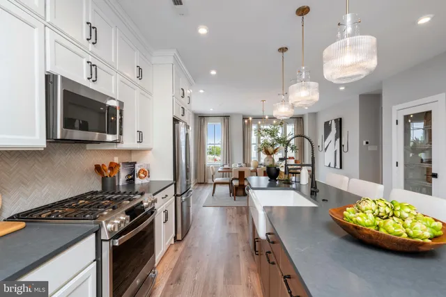 a kitchen with stainless steel appliances granite countertop a stove and a wooden floors