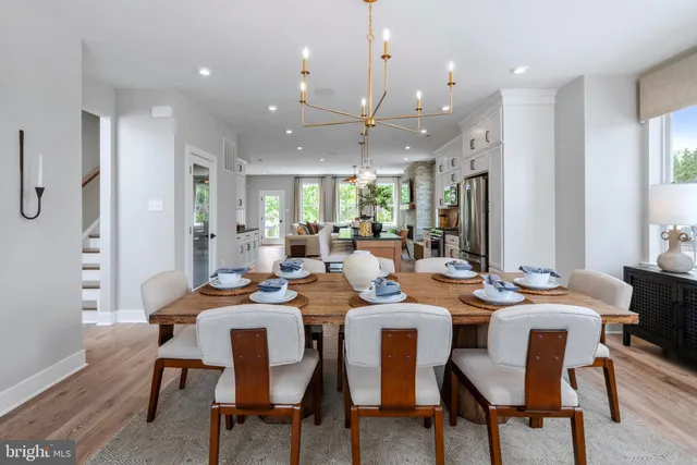 a dining room with furniture a large window and kitchen view