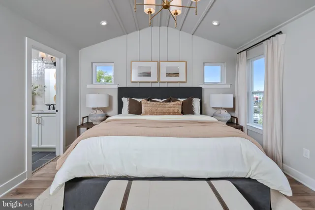 a bedroom with a large bed and a chandelier