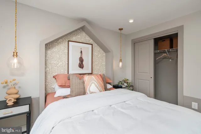 a bed sitting in a spacious bedroom next to a window