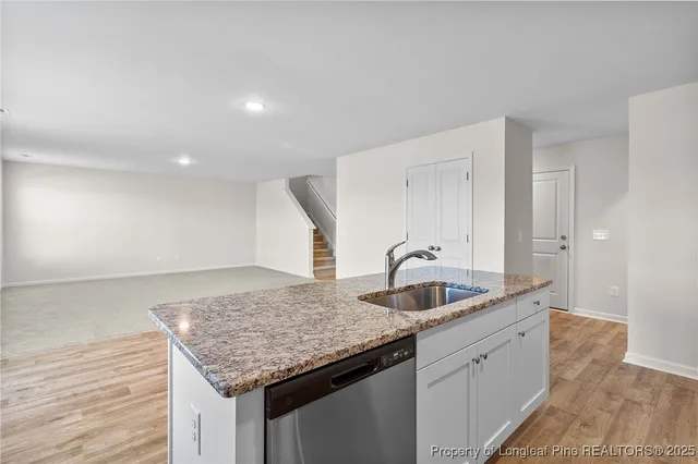 a kitchen with granite countertop a sink and wooden cabinets