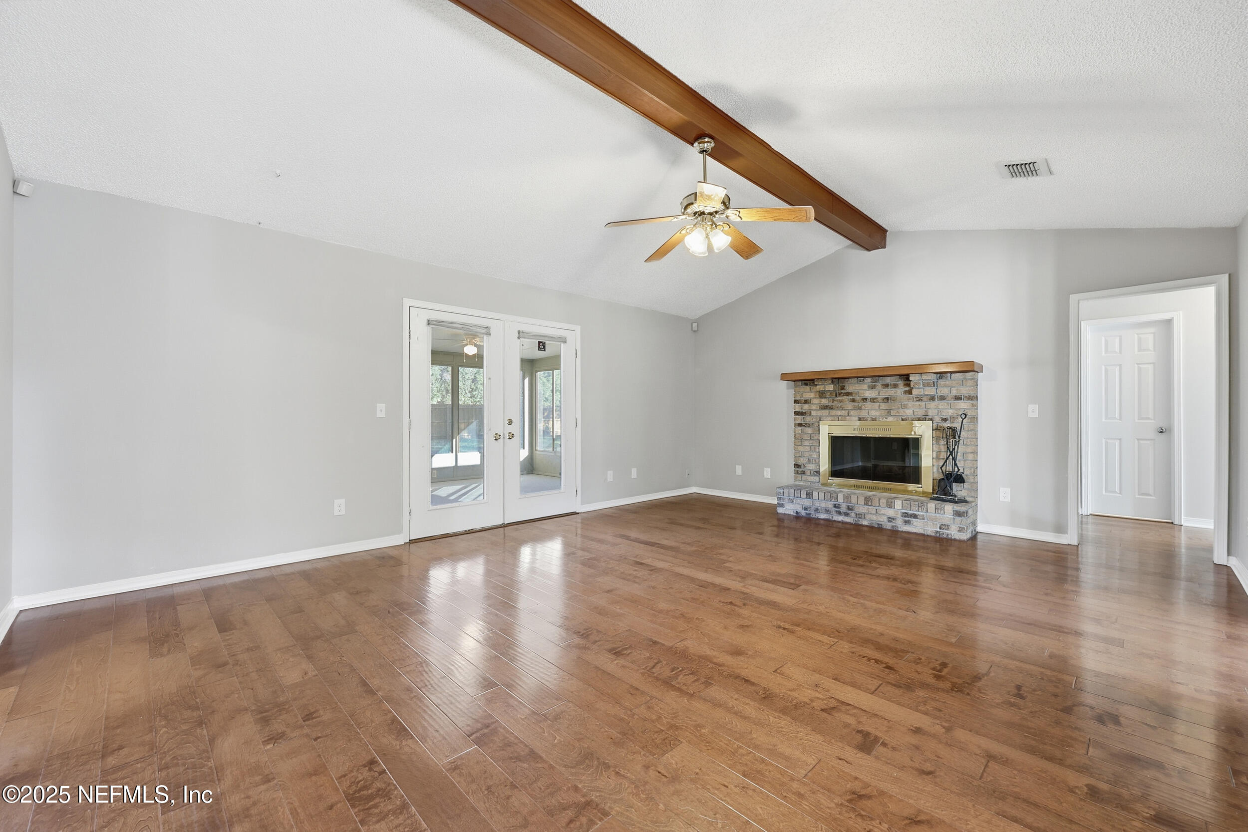3225 Trophy Place Jacksonville, FL 32225 - Photo 3 of 30 an empty room with wooden floor fireplace and windows