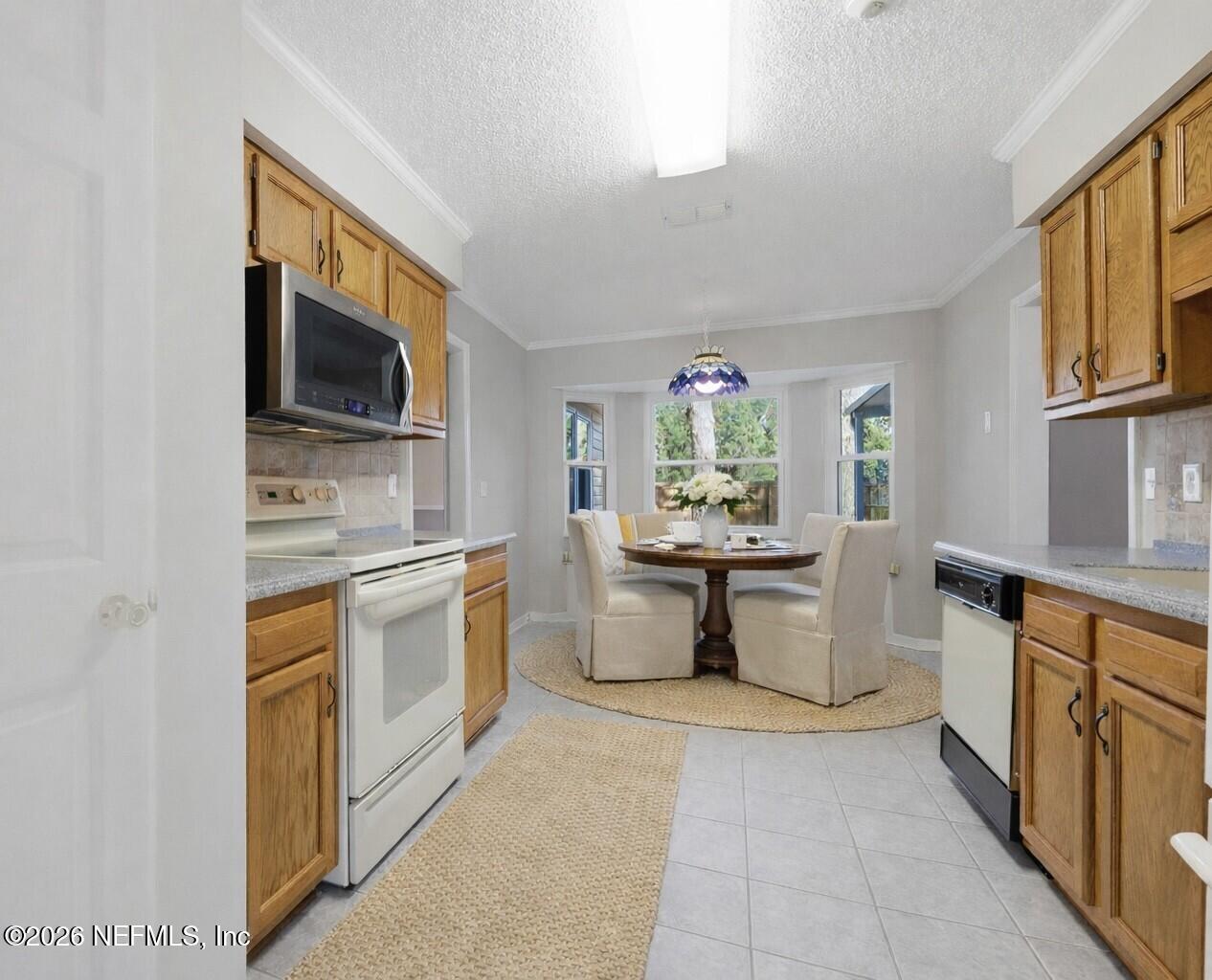 3225 Trophy Place Jacksonville, FL 32225 - Photo 8 of 30 a kitchen with stainless steel appliances a stove sink microwave and cabinets