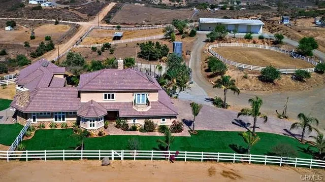 an aerial view of a house with a garden and lake view