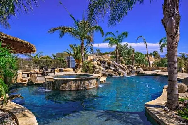 a front view of a house with a yard and potted plants
