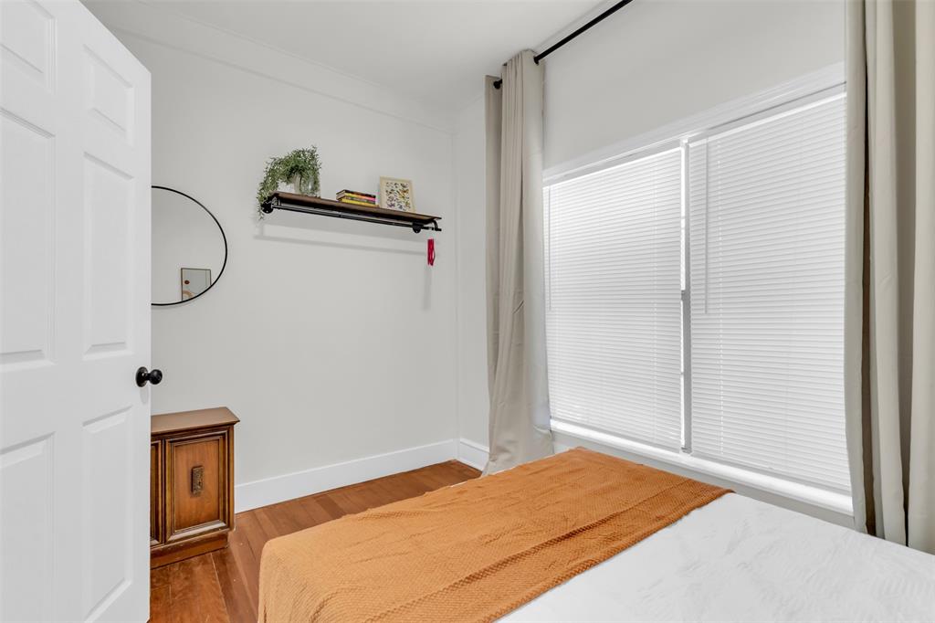 4121 Junius Street, Unit 4123 Dallas, TX 75246 - Photo 9 of 23 a bedroom with a bed and a mirror
