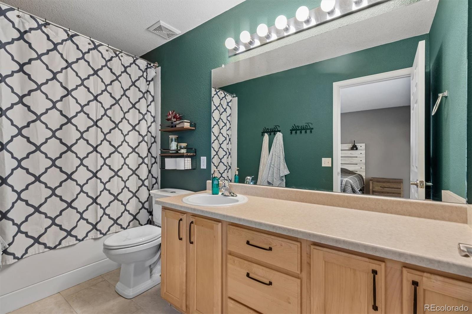 4983 Halifax Court Denver, CO 80249 - Photo 11 of 17 a bathroom with a double vanity sink mirror and toilet