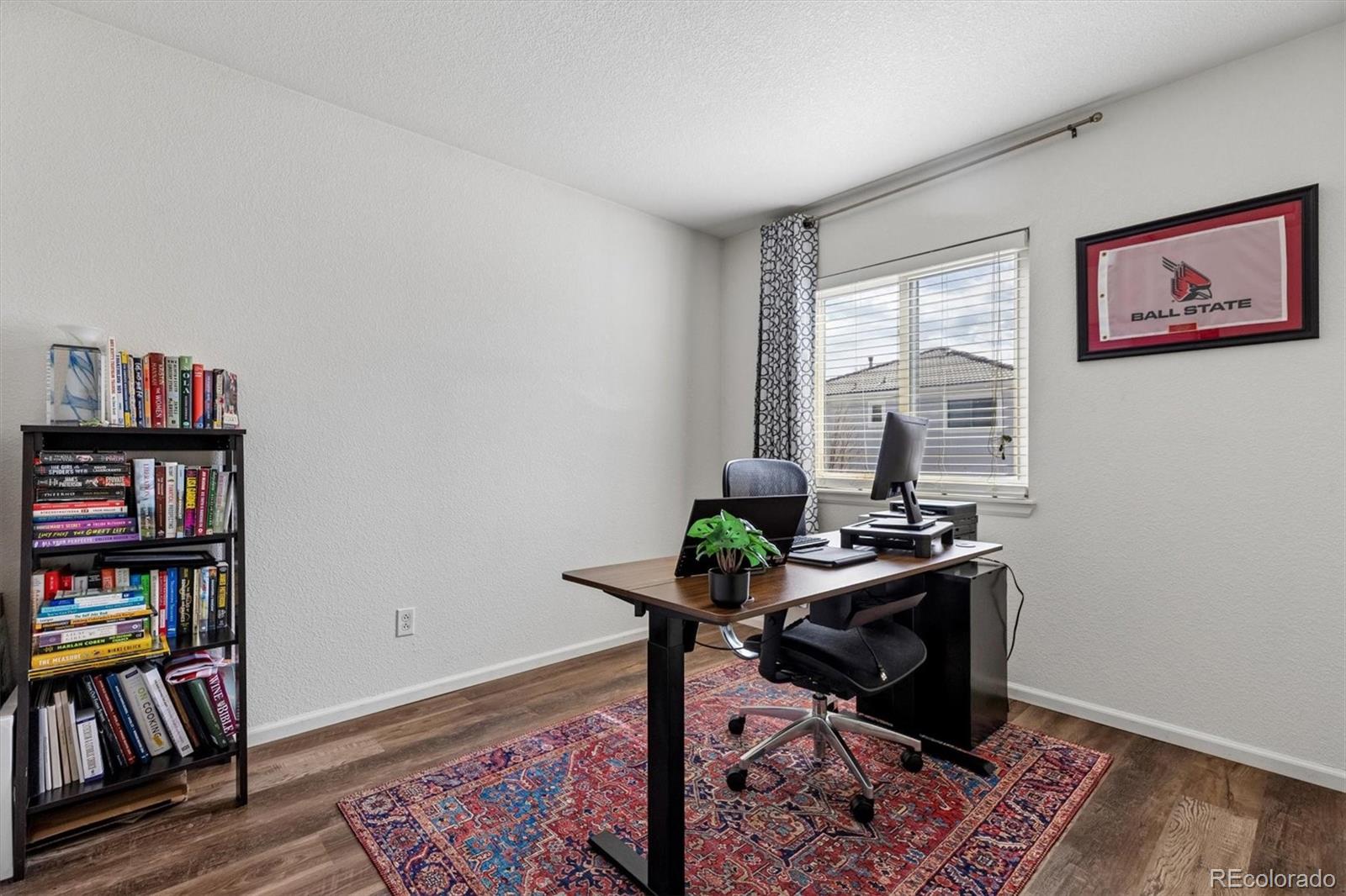 4983 Halifax Court Denver, CO 80249 - Photo 12 of 17 a view of a workspace with furniture and a book shelf