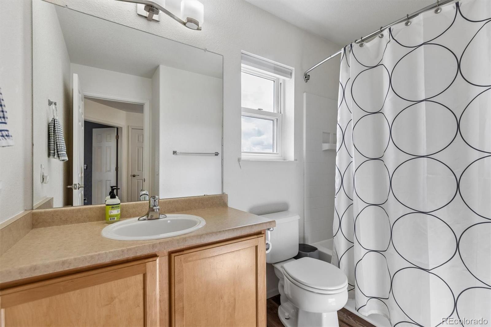 4983 Halifax Court Denver, CO 80249 - Photo 13 of 17 a bathroom with a sink and a mirror