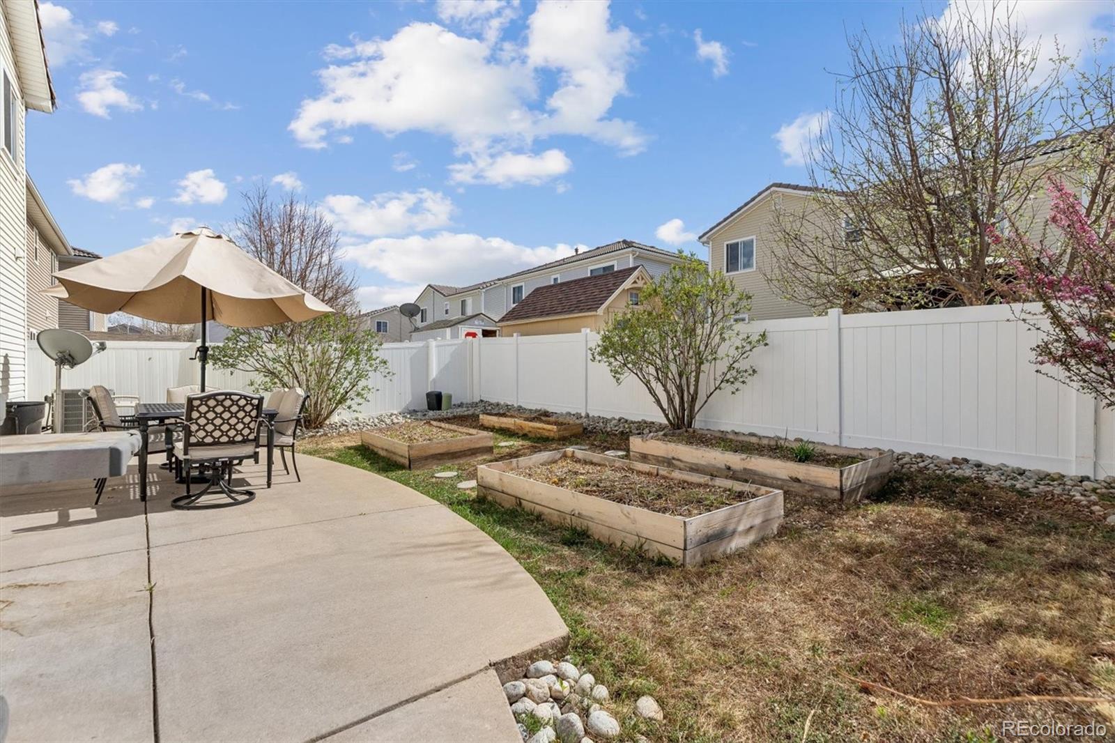 4983 Halifax Court Denver, CO 80249 - Photo 14 of 17 a view of a backyard with table and chairs under an umbrella