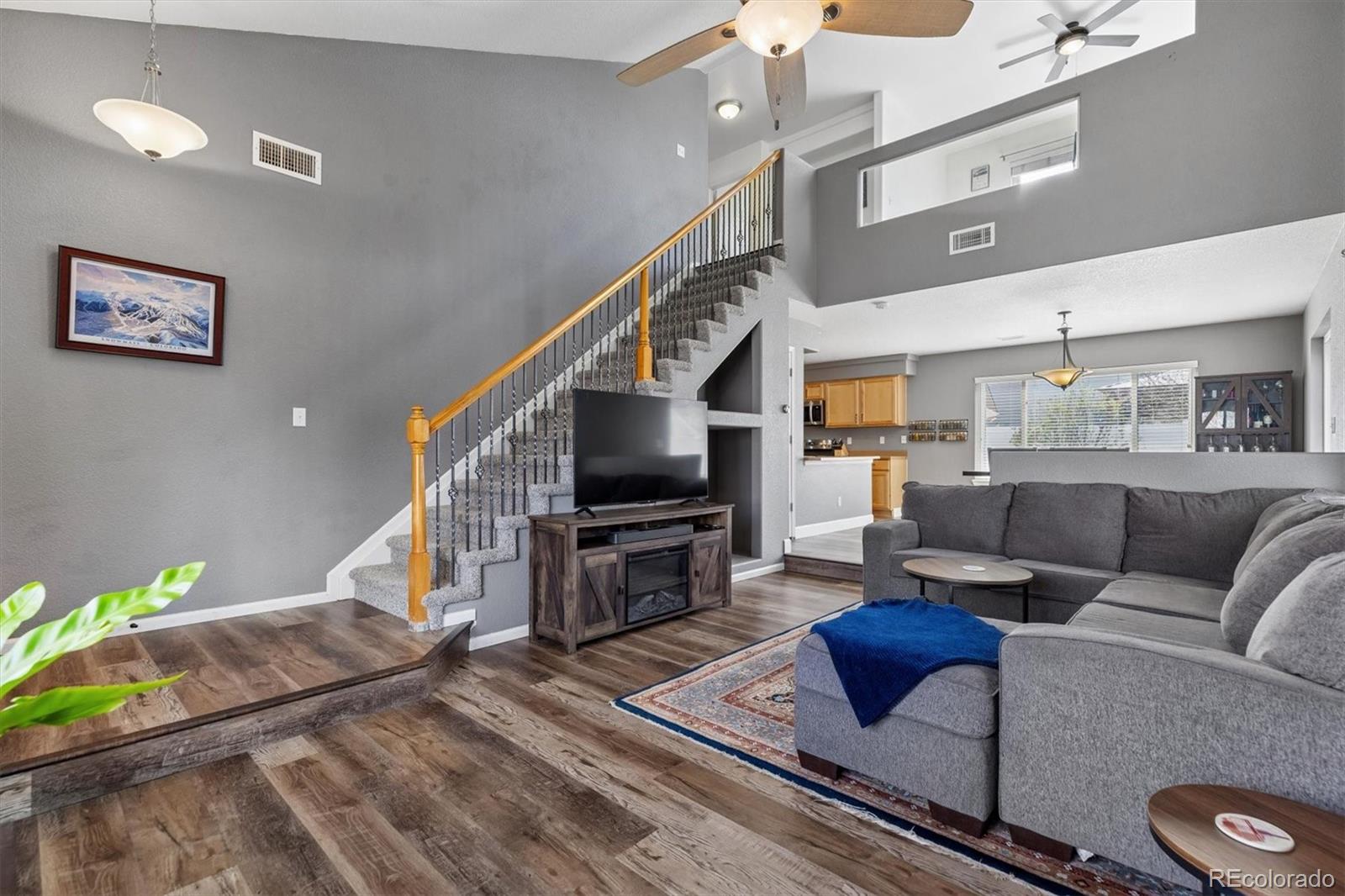 4983 Halifax Court Denver, CO 80249 - Photo 3 of 17 a living room with furniture a flat screen tv and kitchen view