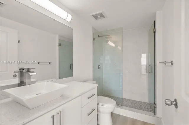 a bathroom with a sink toilet a mirror and shower