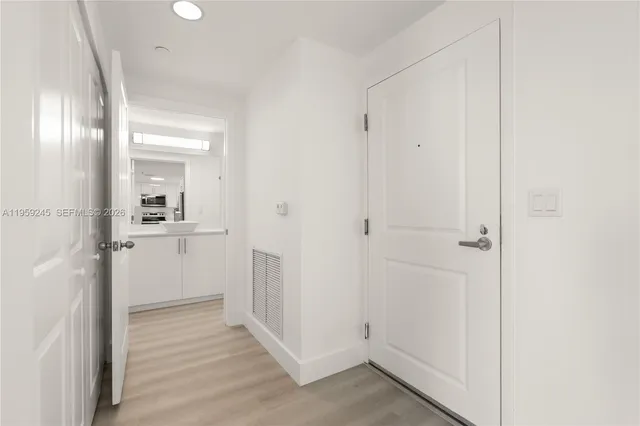 a view of a hallway with wooden floor