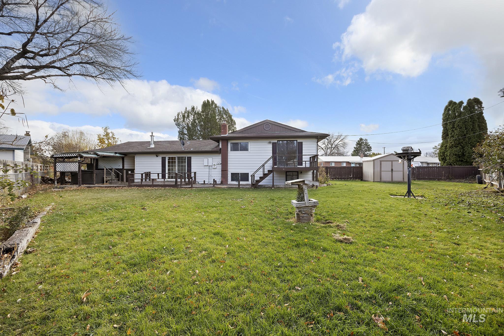 320 East 23rd Drive Burley, ID 83318 - Photo 28 of 34 Back of property featuring a fenced backyard, a storage unit, stairway, and a patio