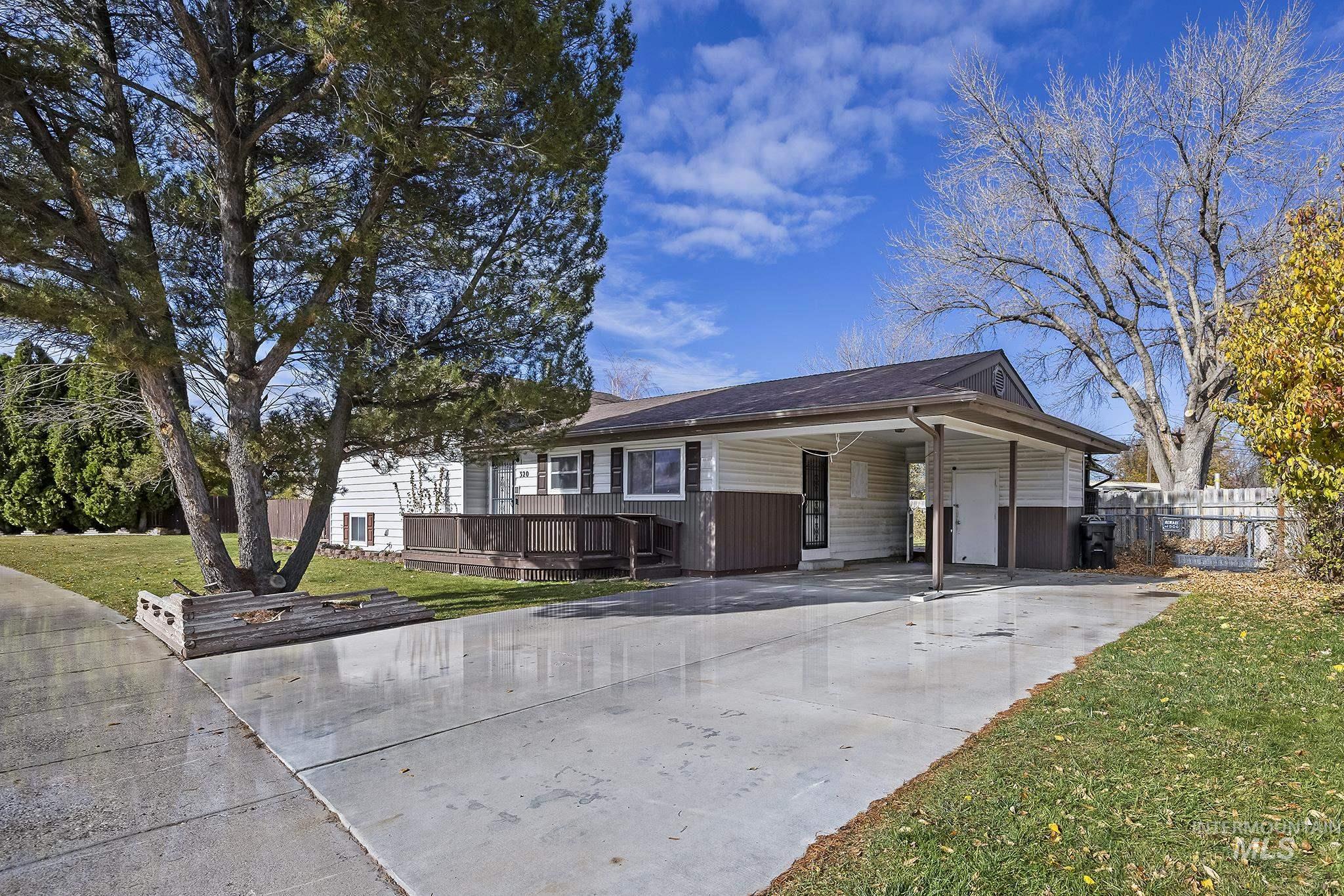 320 East 23rd Drive Burley, ID 83318 - Photo 3 of 34 View of front of home featuring a front lawn, concrete driveway, an attached carport, and a deck