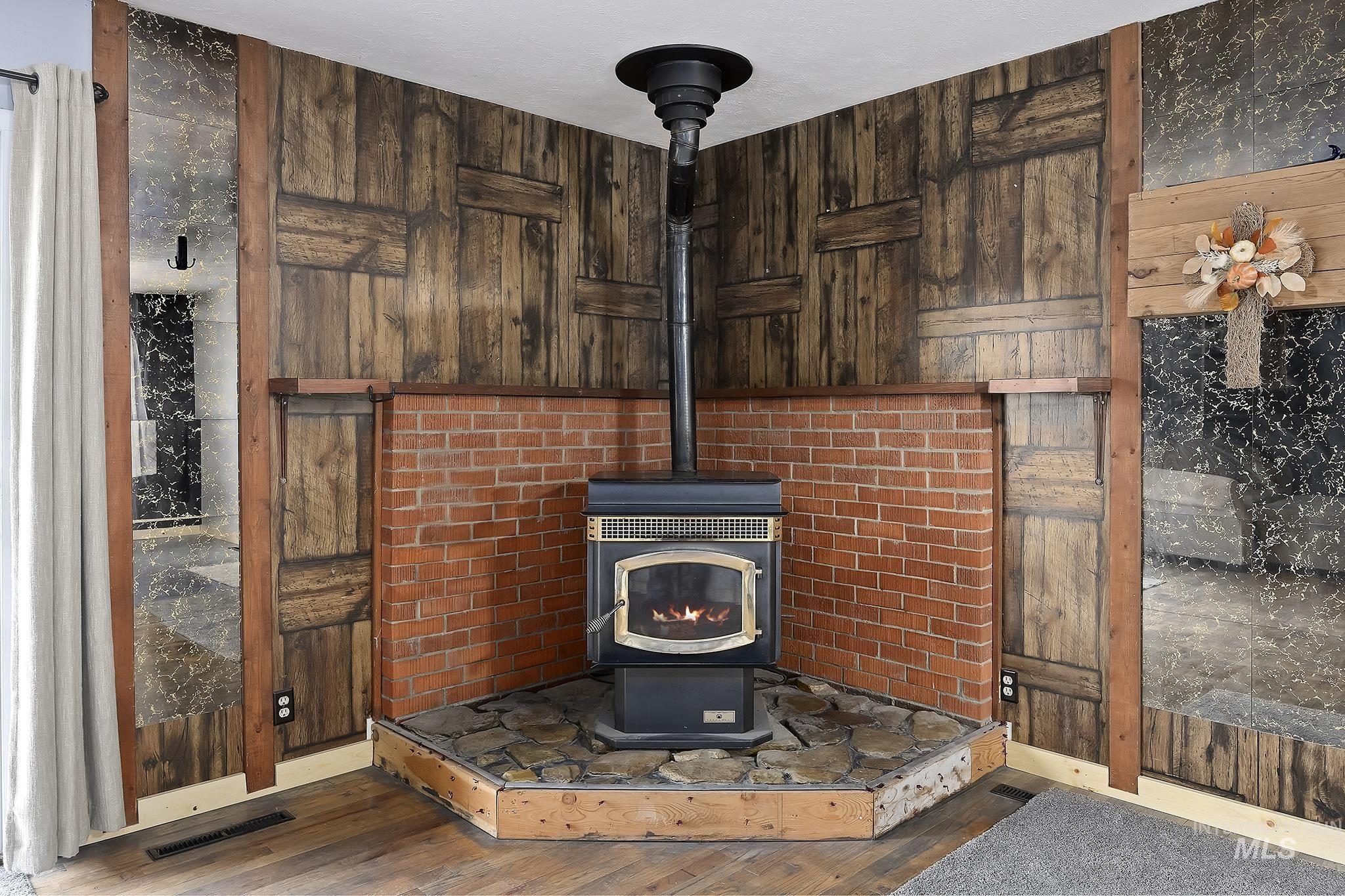 320 East 23rd Drive Burley, ID 83318 - Photo 7 of 34 Detailed view of a wood stove, wood finished floors, and wood walls