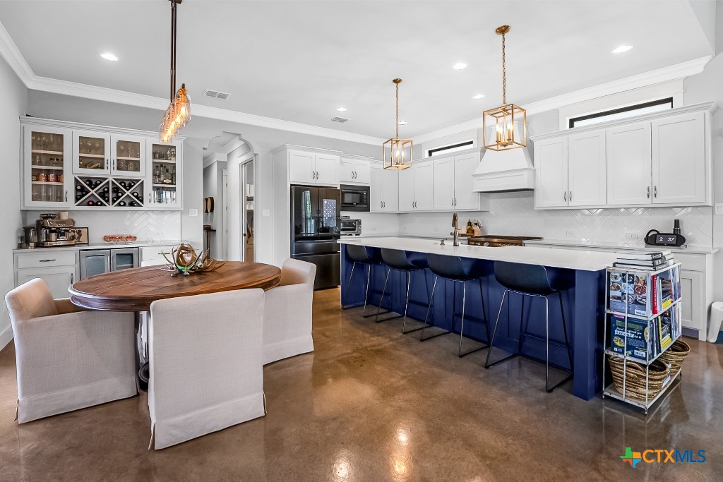 659 Prospect Way New Braunfels, TX 78130 - Photo 14 of 32 a large kitchen with stainless steel appliances kitchen island granite countertop a stove a sink dishwasher and a wooden cabinets with wooden floor
