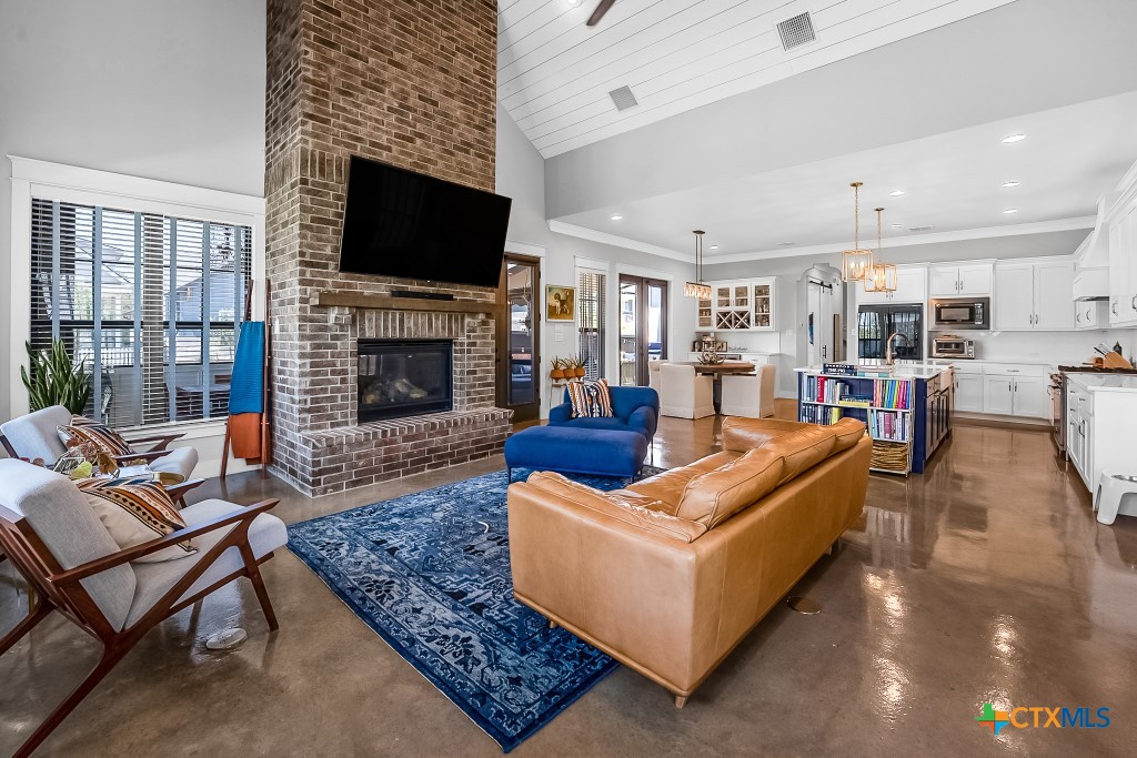 659 Prospect Way New Braunfels, TX 78130 - Photo 10 of 32 a living room with furniture a fireplace and a flat screen tv