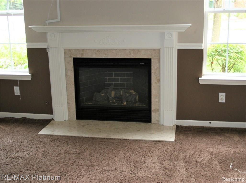 4074 Hampton Ridge Boulevard, Unit 58 Howell, MI 48843 - Photo 8 of 37 Marble surround and nice woodworking dress up the fireplace