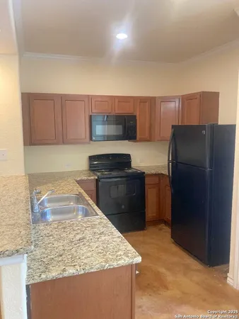 a kitchen with a refrigerator sink and cabinets