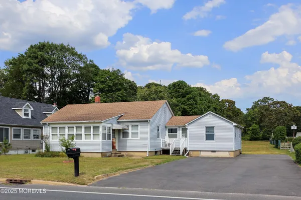a front view of a house with a garden and trees
