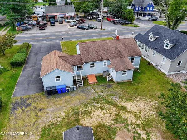 an aerial view of a house with swimming pool and large trees