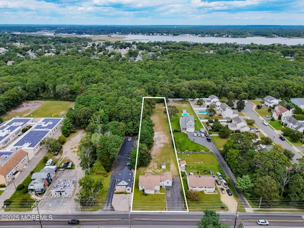 an aerial view of residential houses with outdoor space and trees