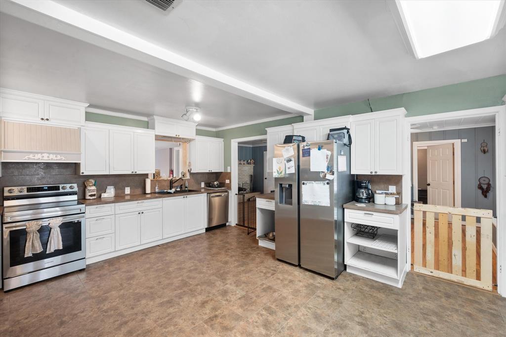 a large kitchen with cabinets and stainless steel appliances