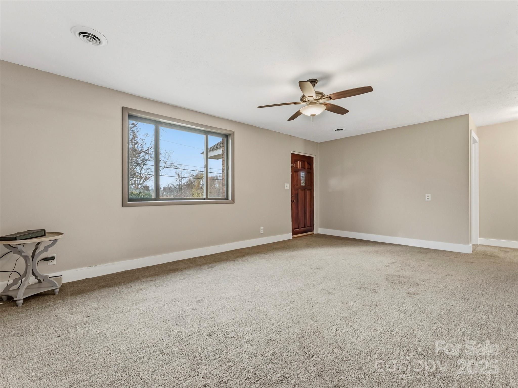 605 Dana Road Hendersonville, NC 28792 - Photo 12 of 38 a view of an empty room with a ceiling fan and a window
