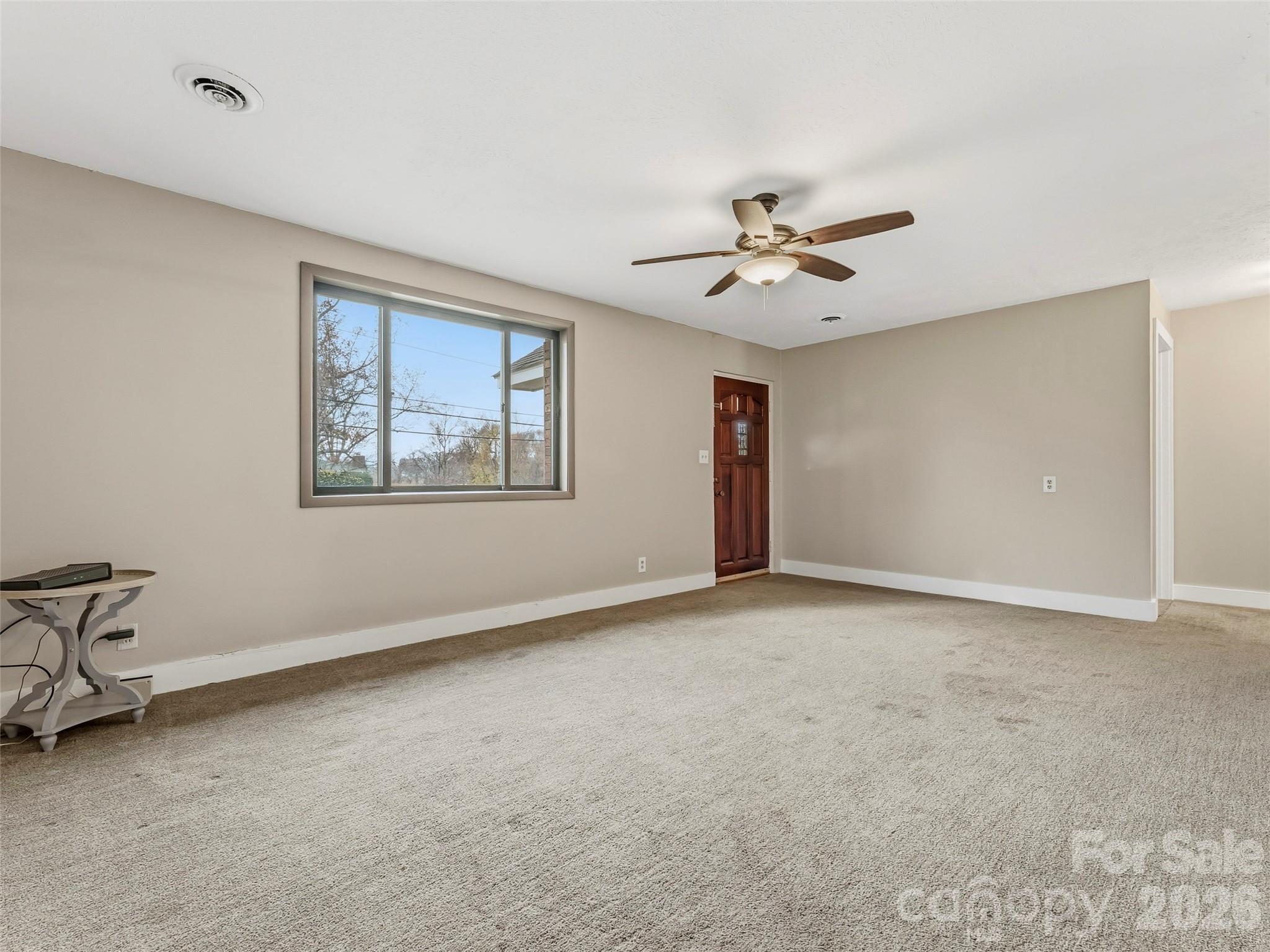 605 Dana Road Hendersonville, NC 28792 - Photo 13 of 38 a view of an empty room with a ceiling fan and a window