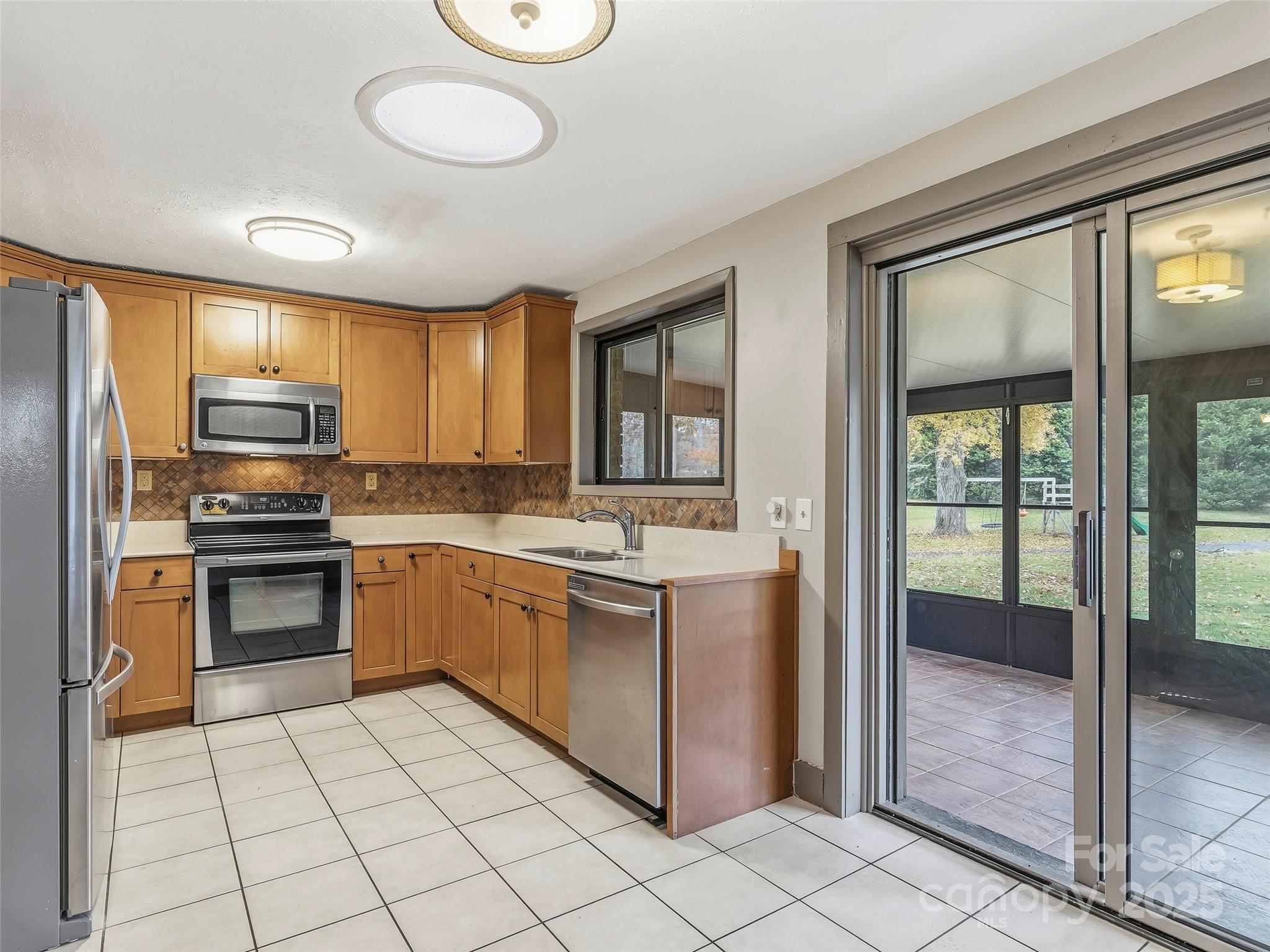605 Dana Road Hendersonville, NC 28792 - Photo 14 of 38 a kitchen with stainless steel appliances granite countertop a stove top oven a sink dishwasher a refrigerator and a microwave